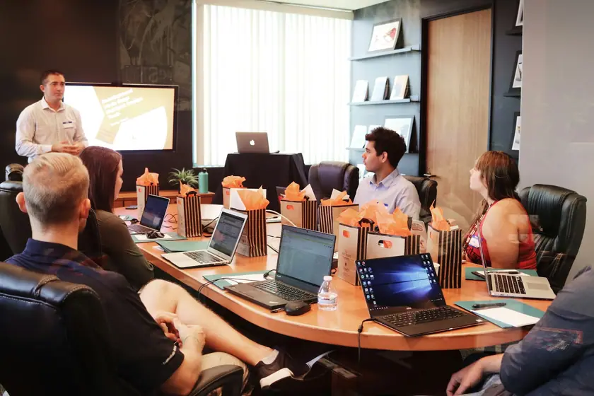 Software project planning meeting with a team reviewing business requirements around laptops
